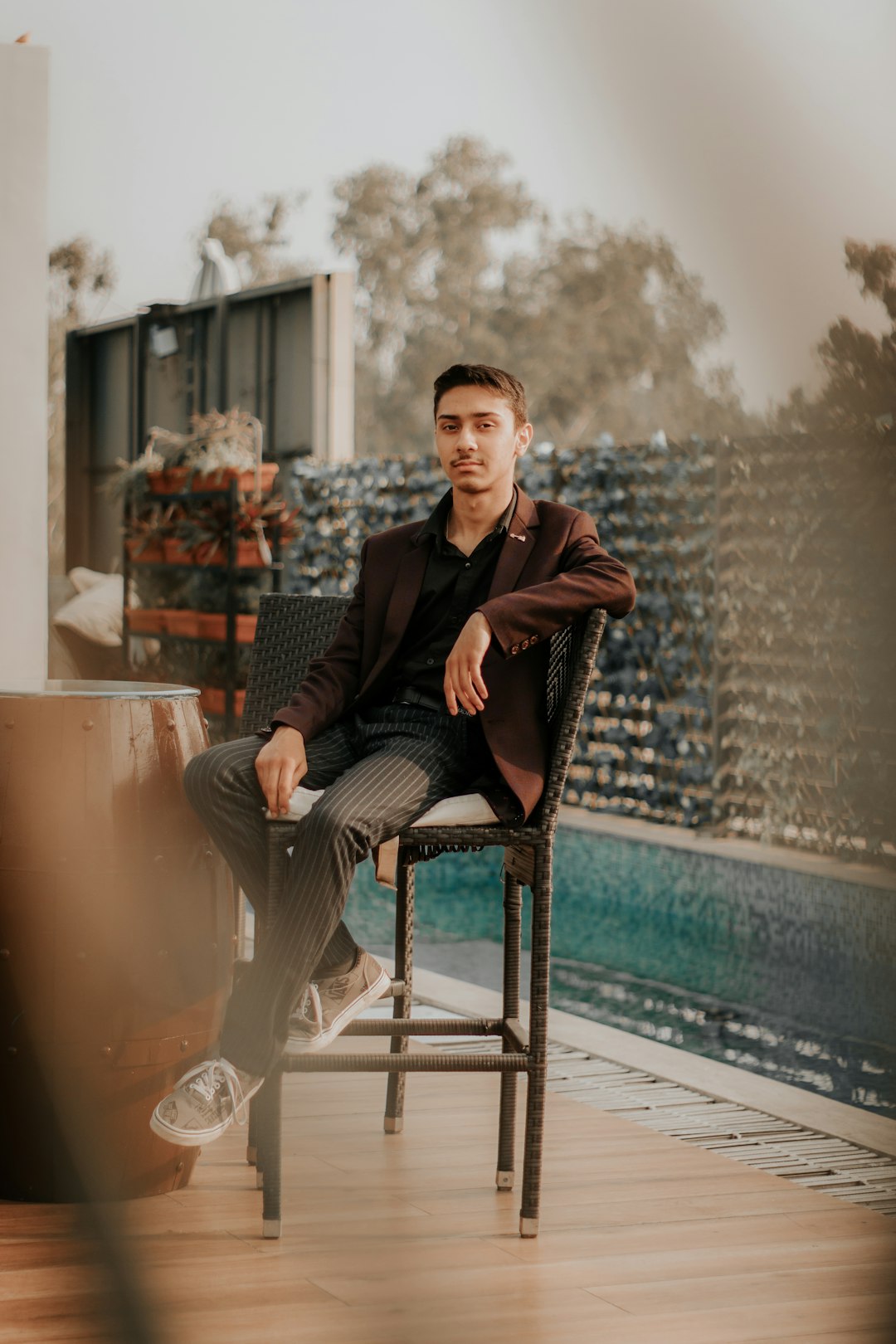 man in black suit sitting on brown wooden chair