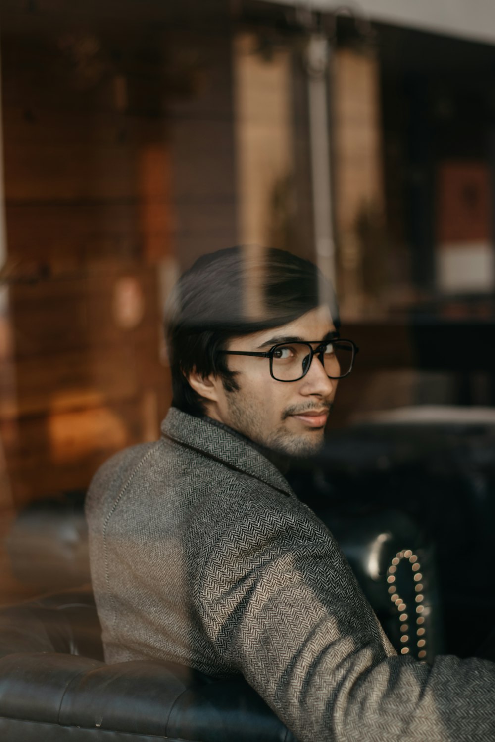 man in gray coat wearing black framed eyeglasses