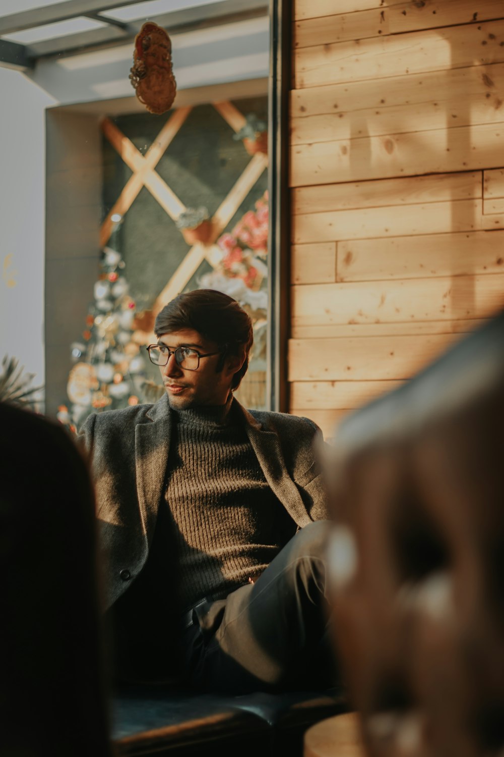 man in gray coat wearing black framed eyeglasses