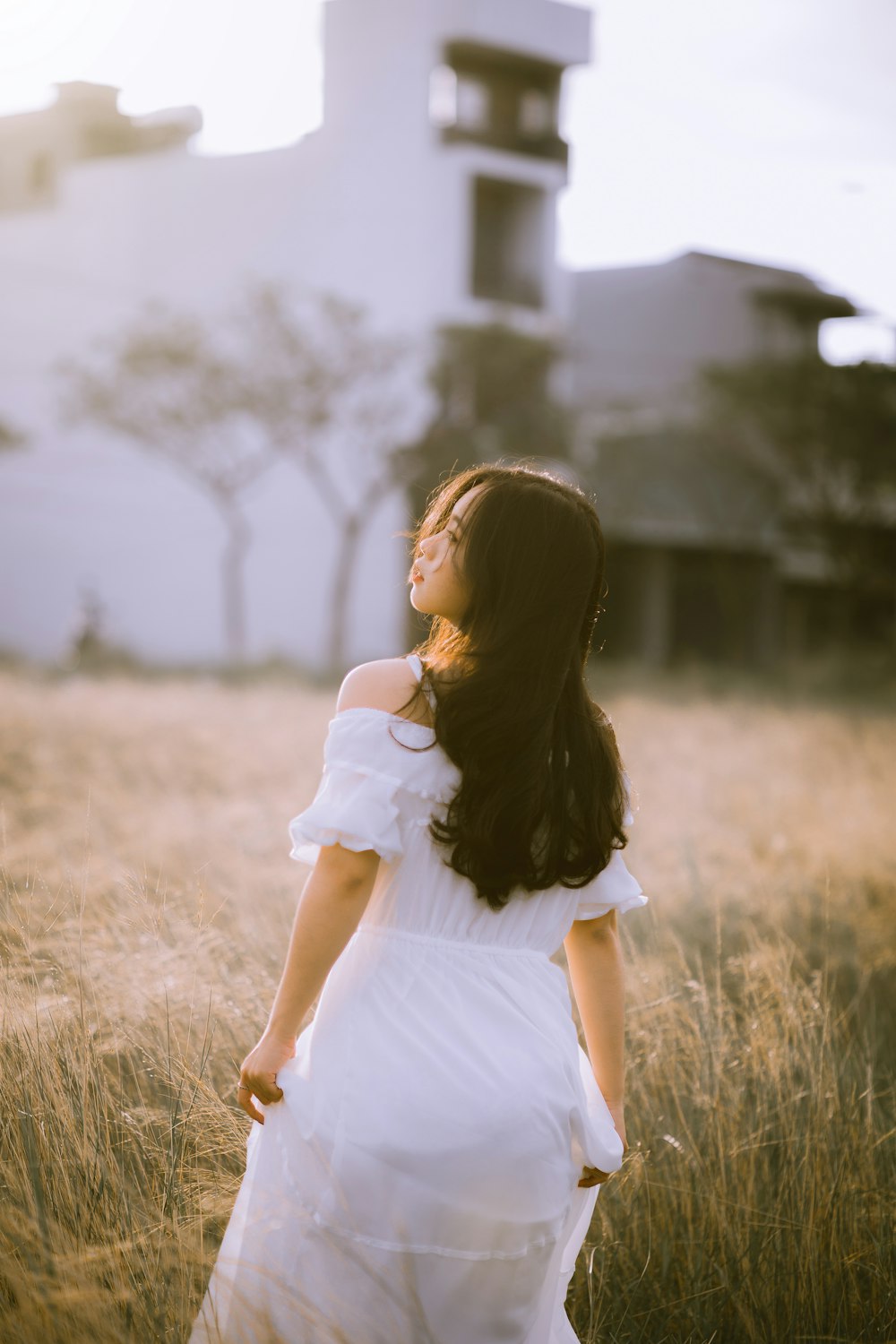woman in white dress standing on grass field during daytime
