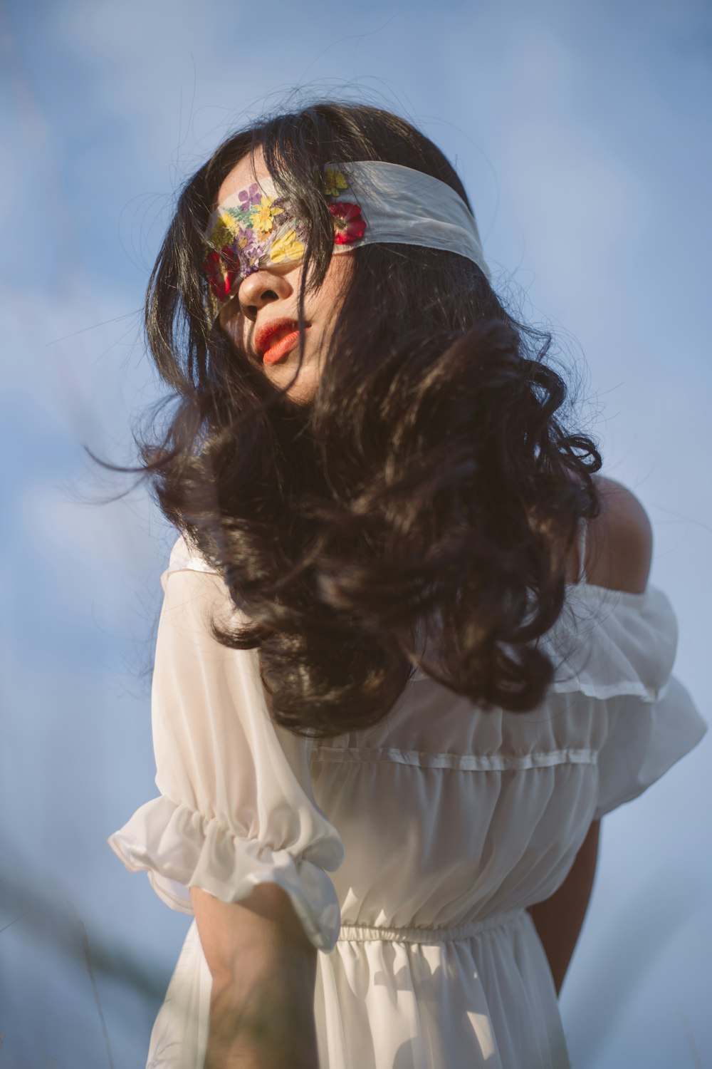 woman in white long sleeve shirt with red and yellow flower on her head