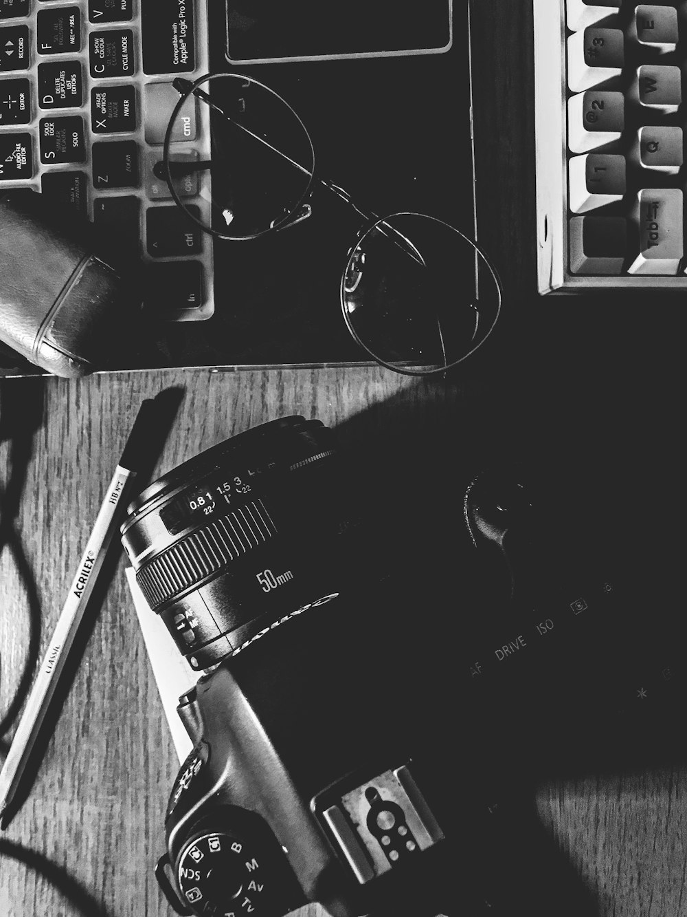 black nikon dslr camera beside black and silver computer keyboard