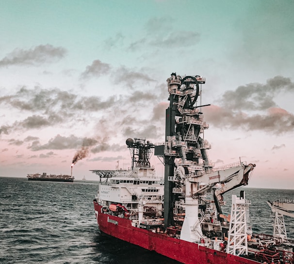 red and white ship on sea under cloudy sky during daytime