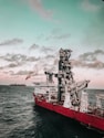 red and white ship on sea under cloudy sky during daytime