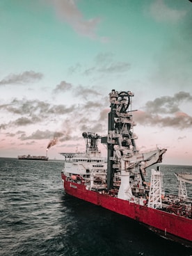 red and white ship on sea under cloudy sky during daytime