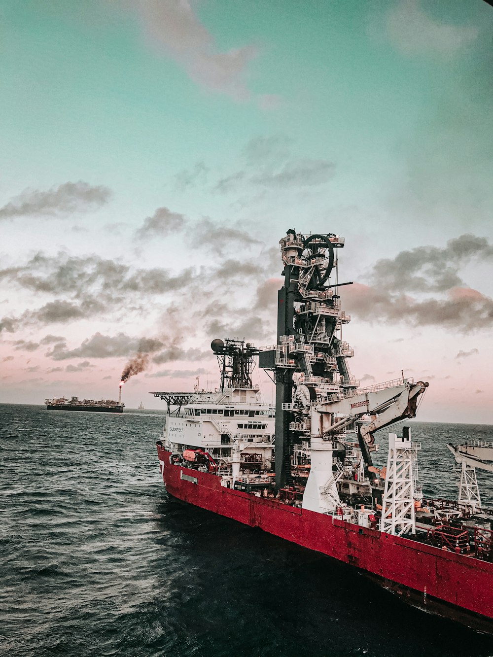 barco rojo y blanco en el mar bajo el cielo nublado durante el día