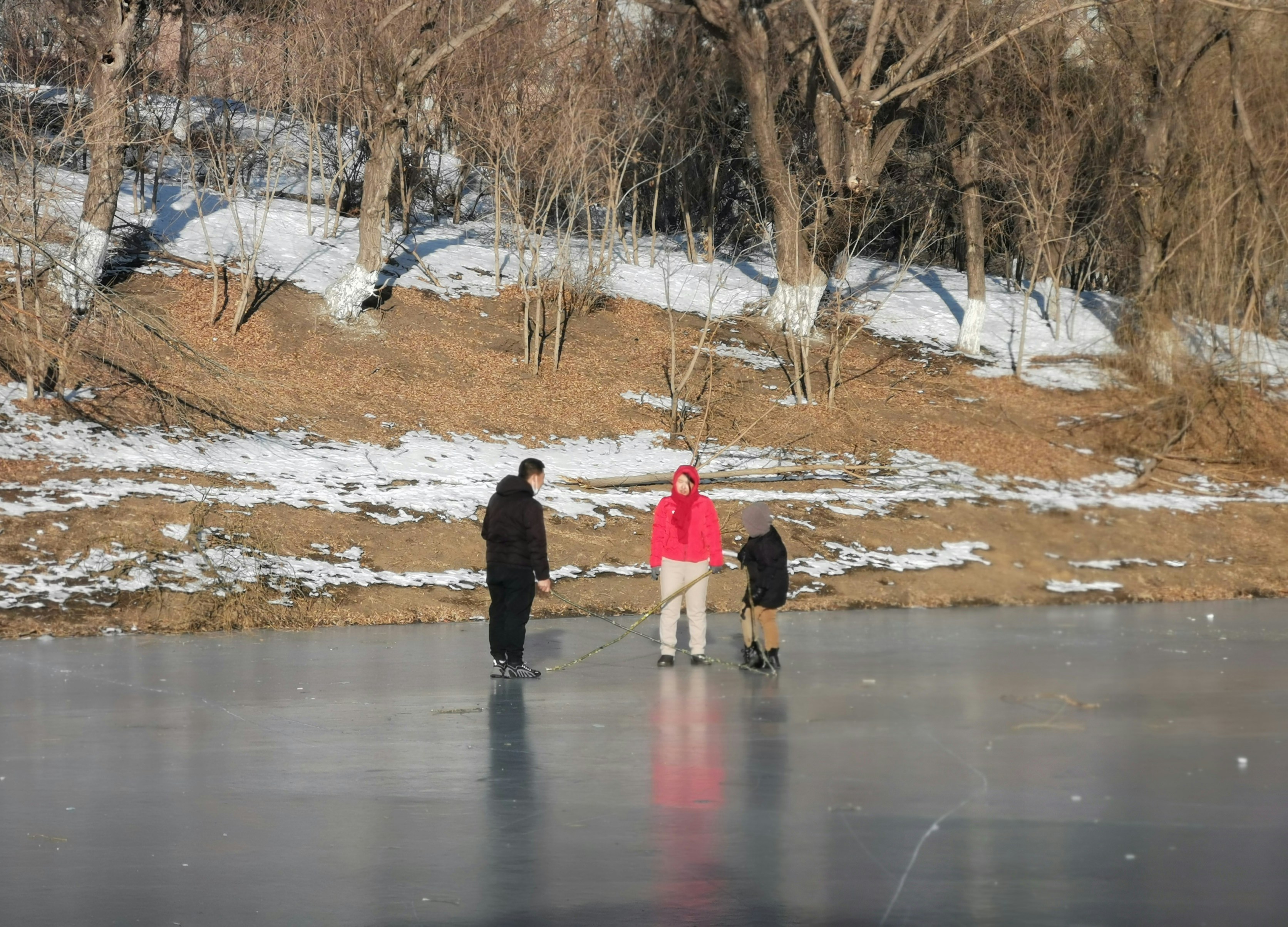 2 person walking on snow covered ground during daytime