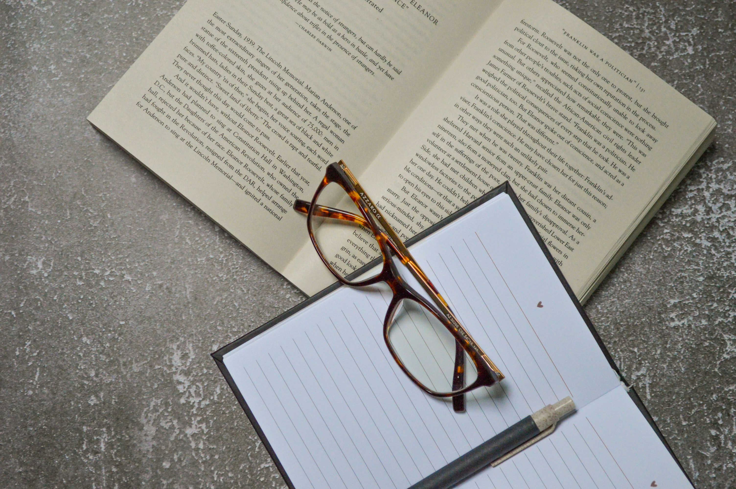 brown framed eyeglasses on white printer paper