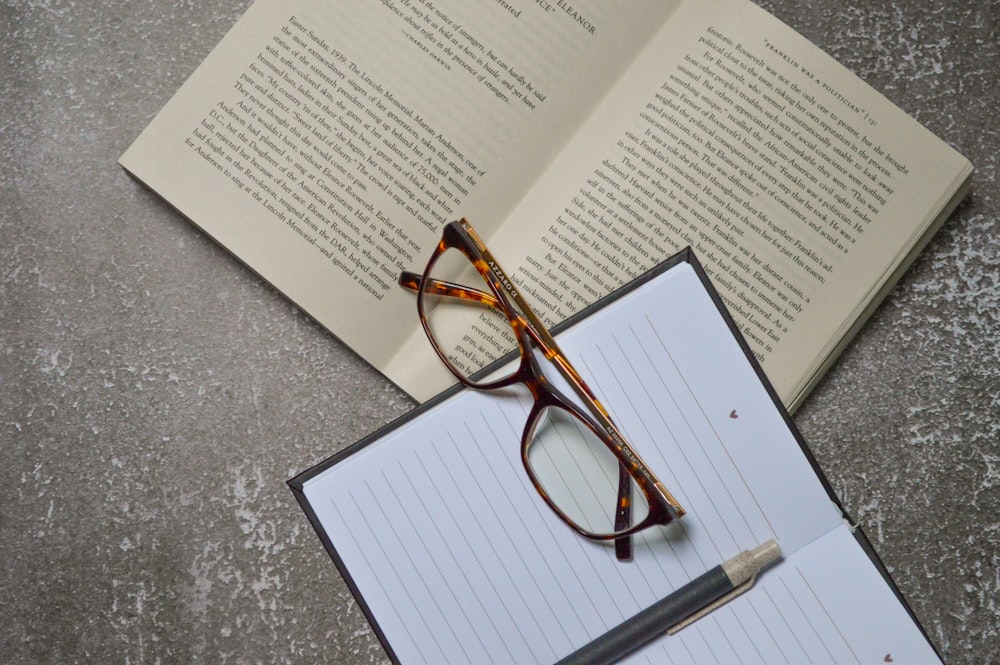 brown framed eyeglasses on white printer paper