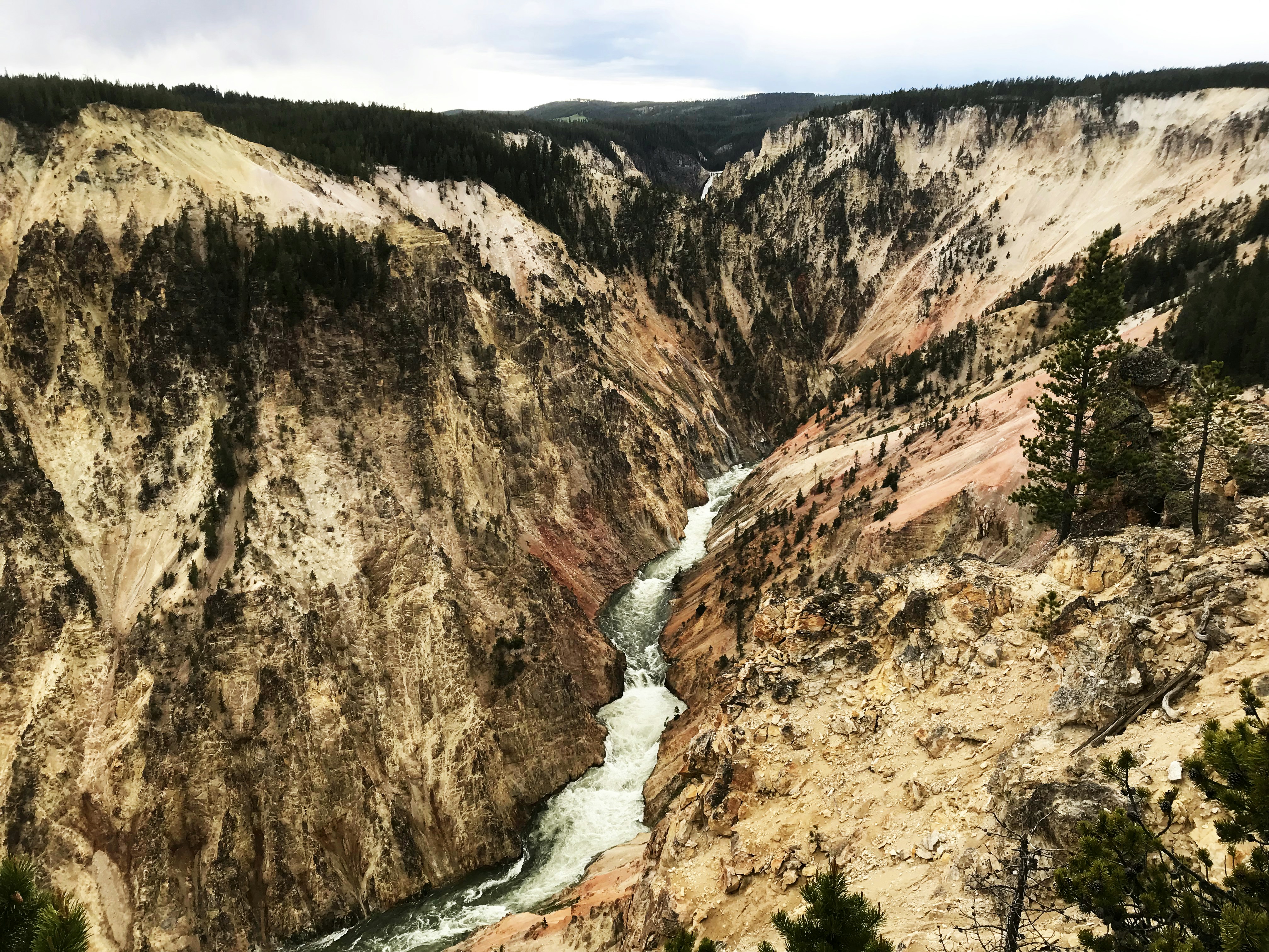 brown rocky mountain beside river during daytime