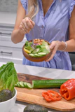 person holding green vegetable on brown ceramic plate