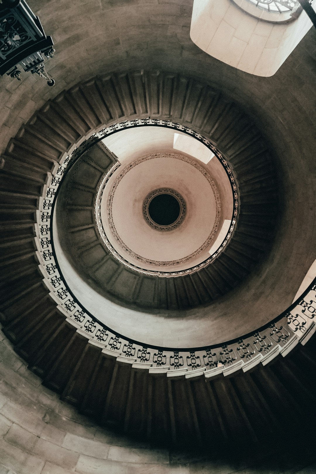 brown spiral staircase with black metal railings