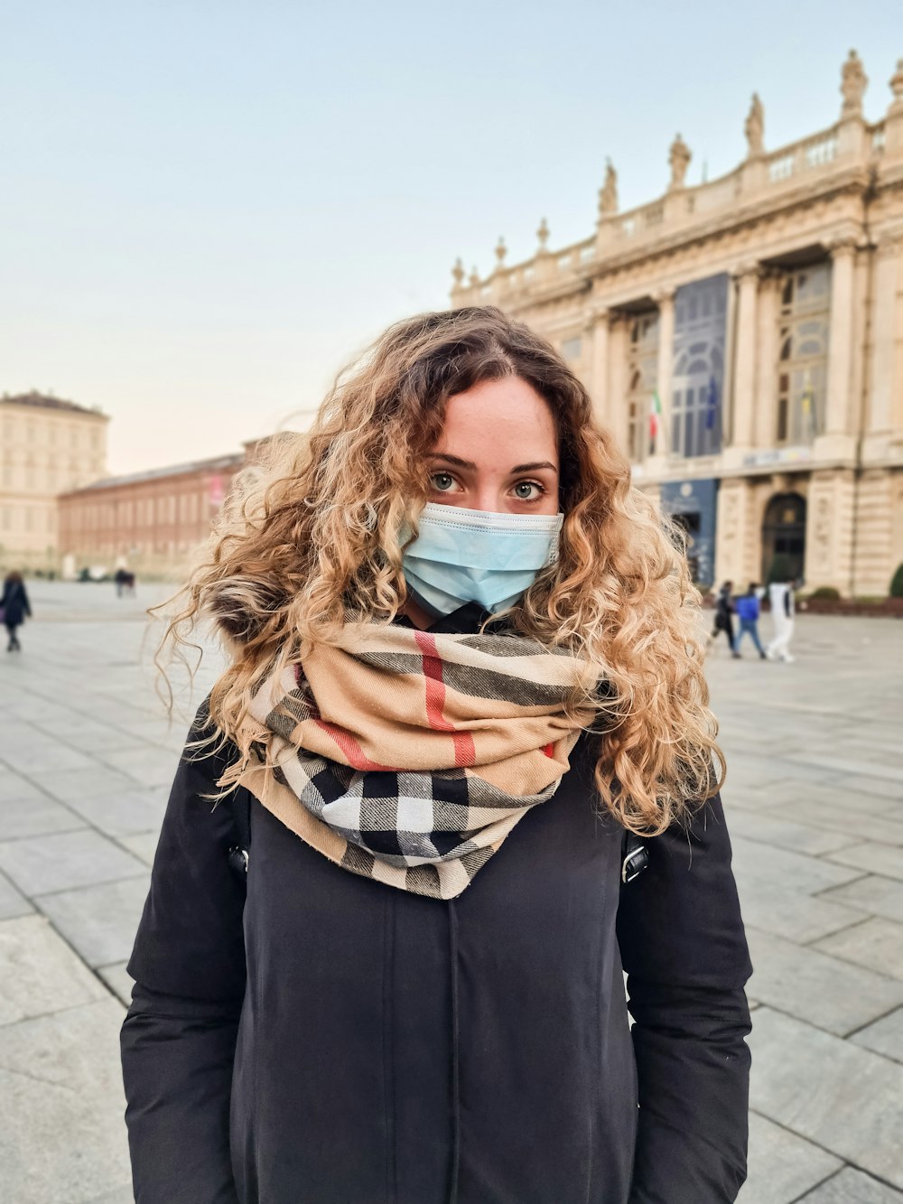 woman in black coat with scarf on her neck