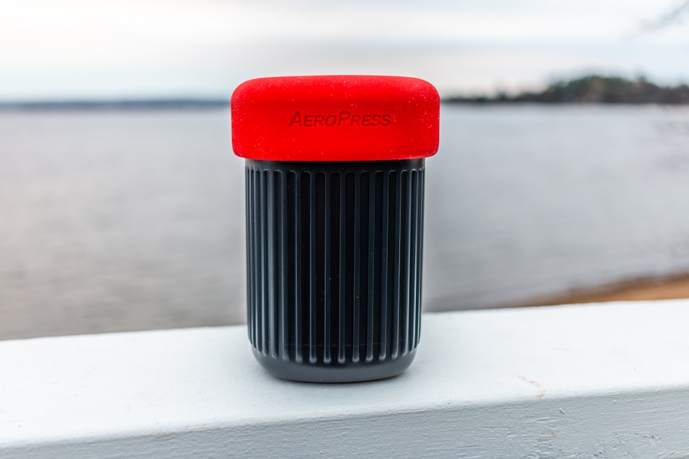 red and black plastic container on white table