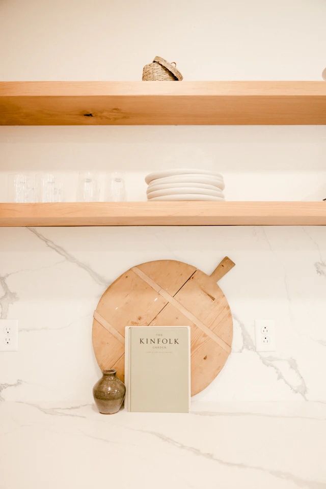 Oak shelves above a white marble backsplash