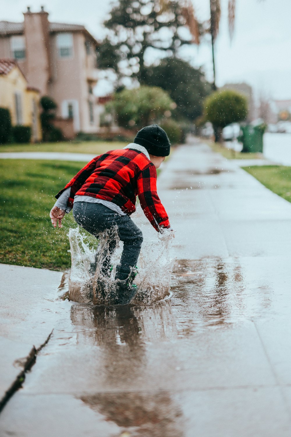 boy in red and blue striped sweater and blue denim jeans running on road during daytime