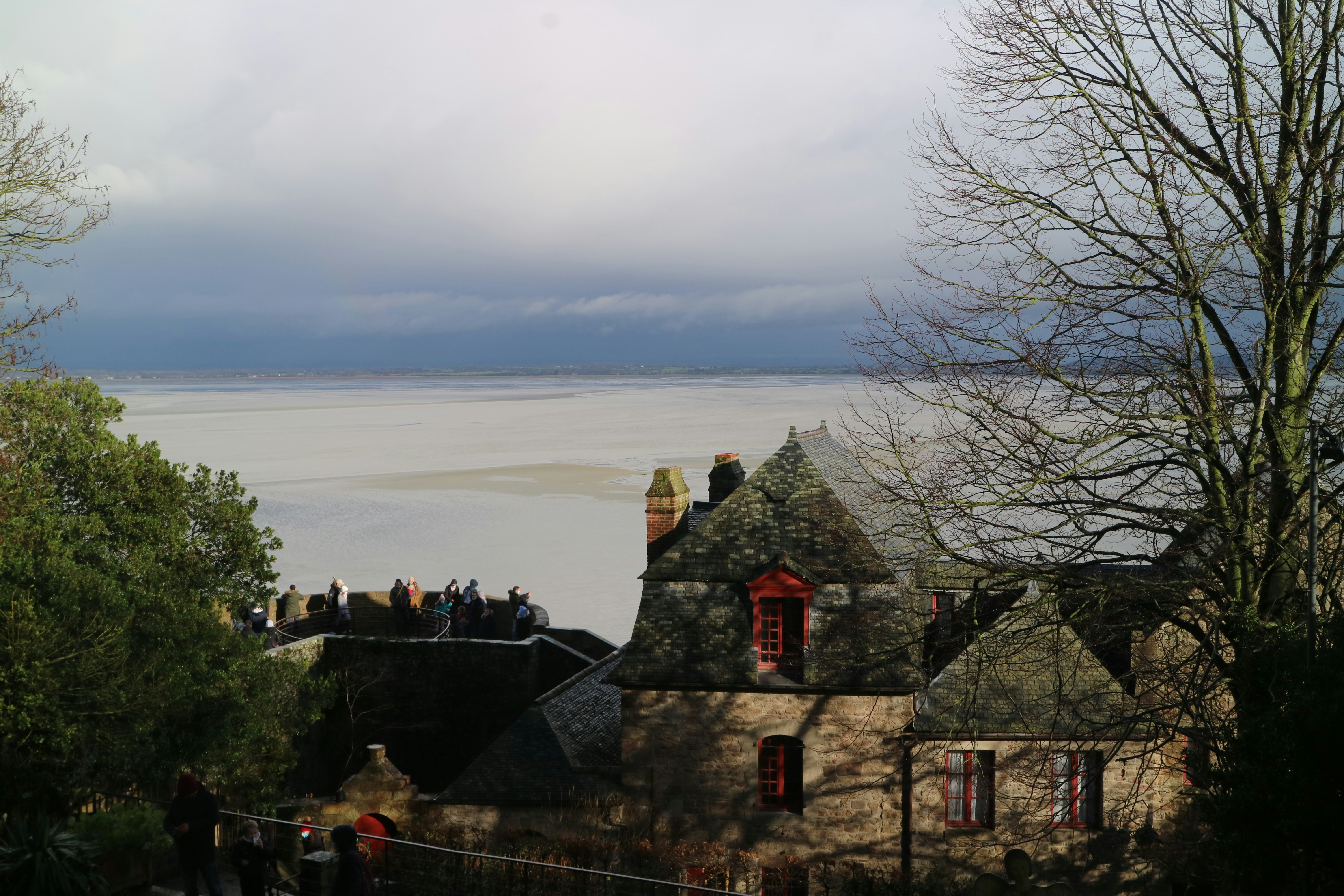 red and gray concrete house near body of water during daytime