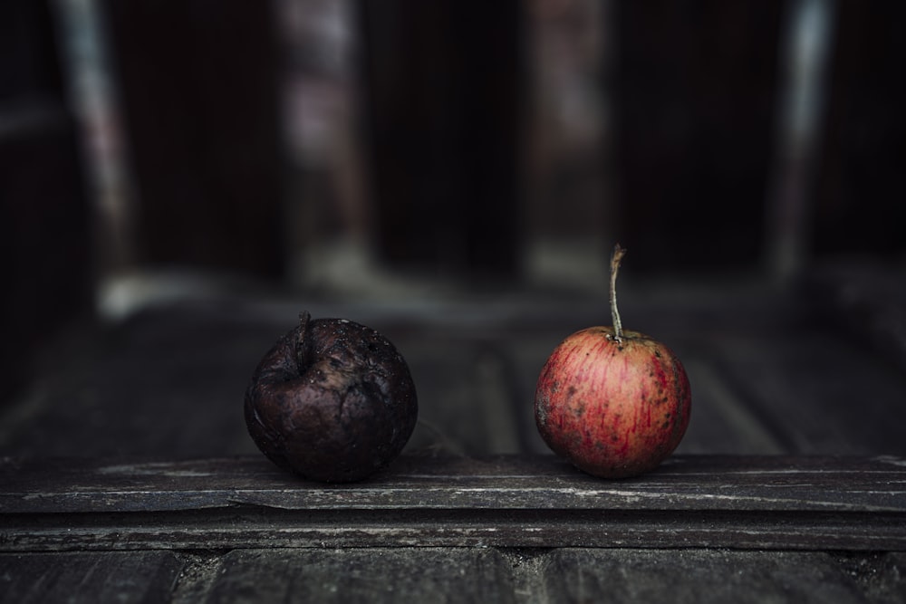 red and black round fruits on black wooden table