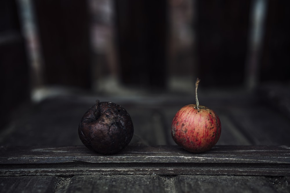 fruits ronds rouges et noirs sur table en bois noir