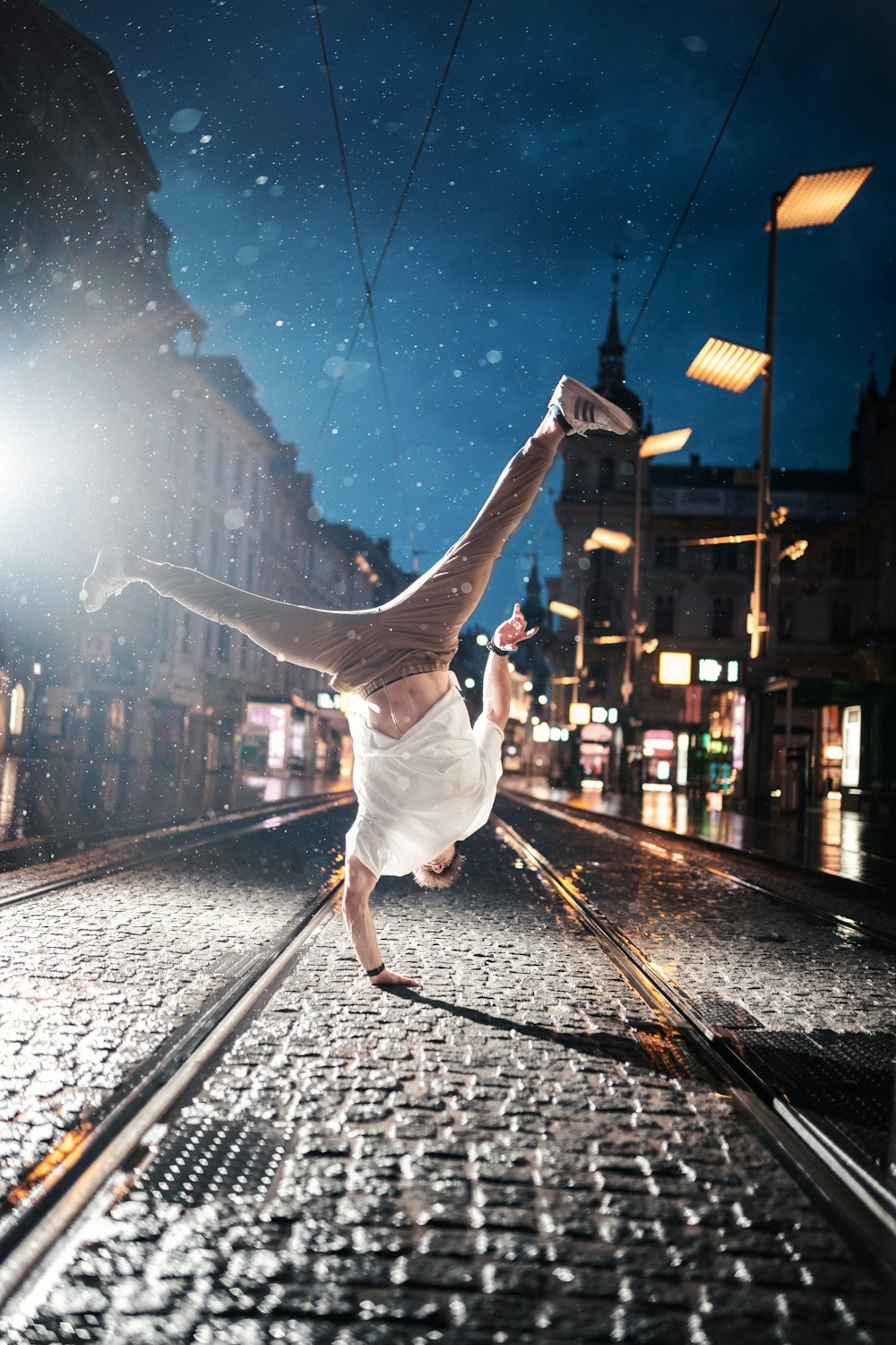 woman in white dress jumping on train rail during night time