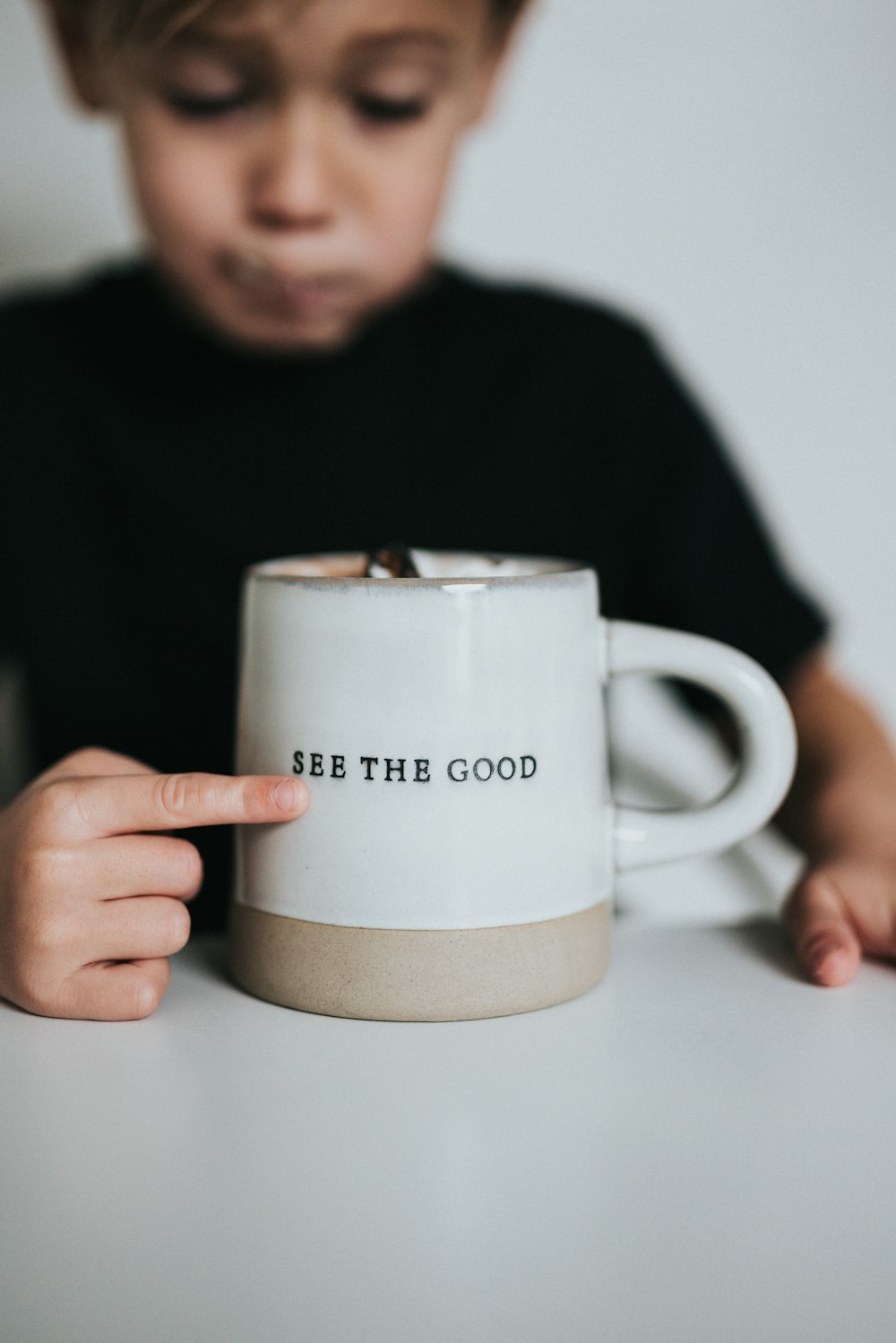 Chemise à manches longues homme en noir tenant une tasse en céramique blanche