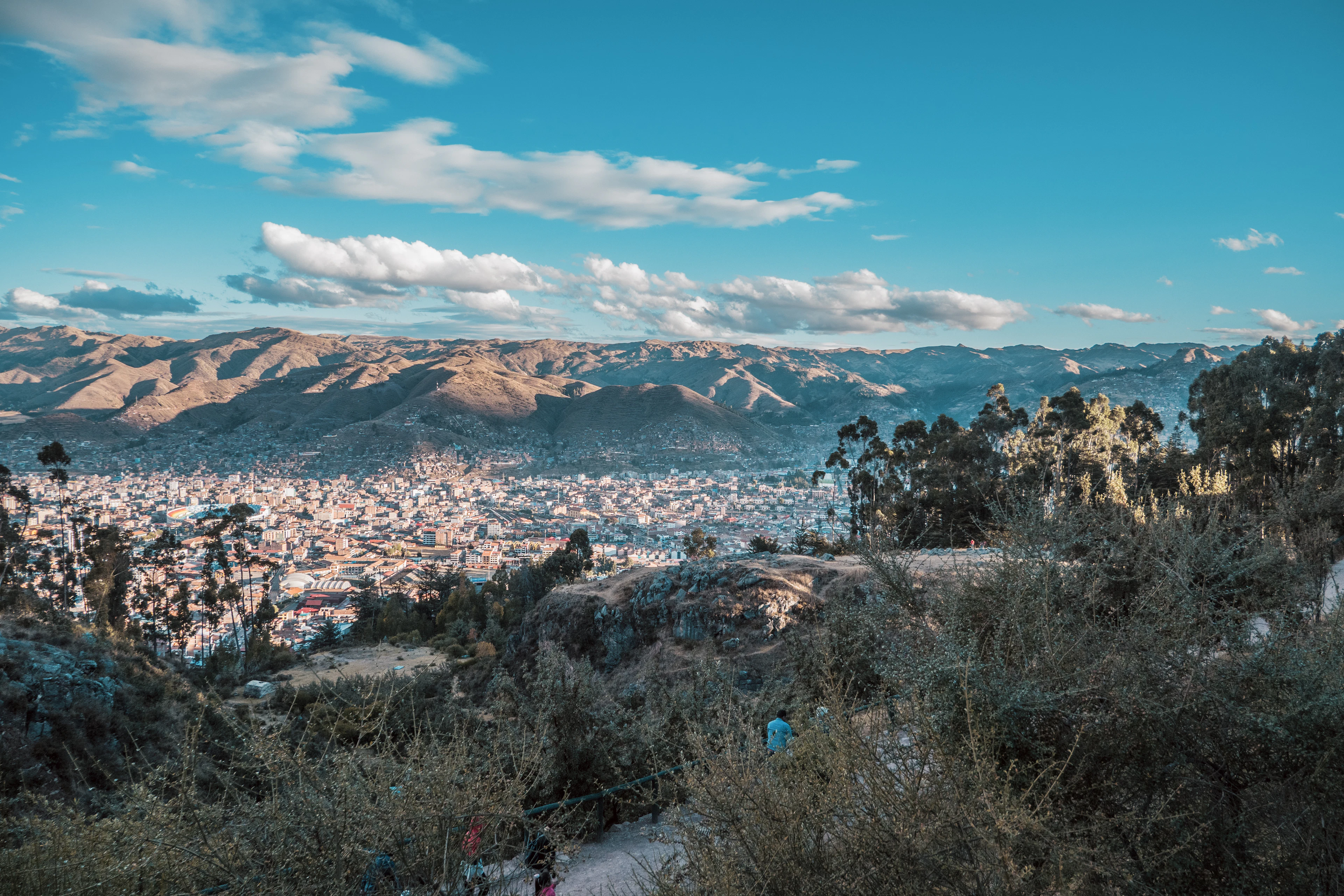 The rooftops of Cusco and surrounding hills in evening light, seen from near Qenqo