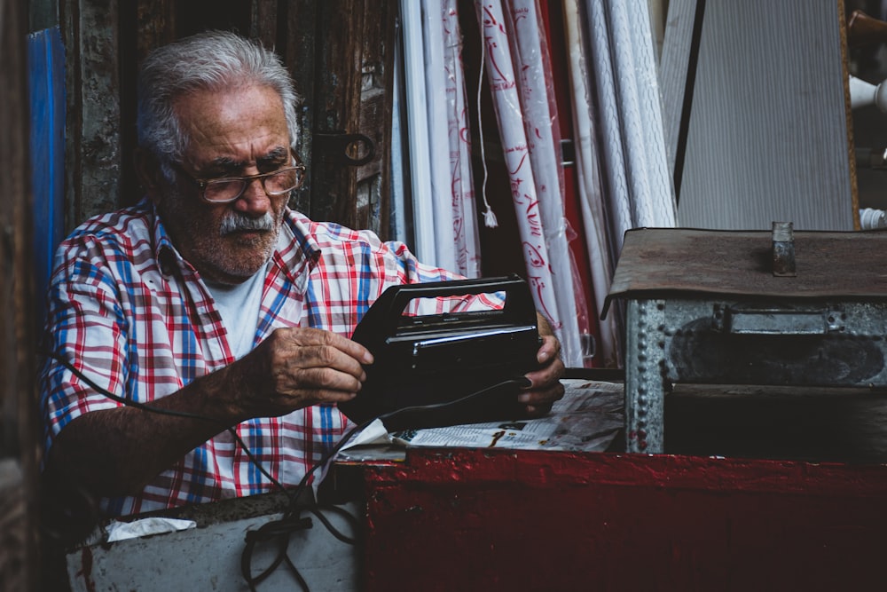 an old man is looking at a wallet