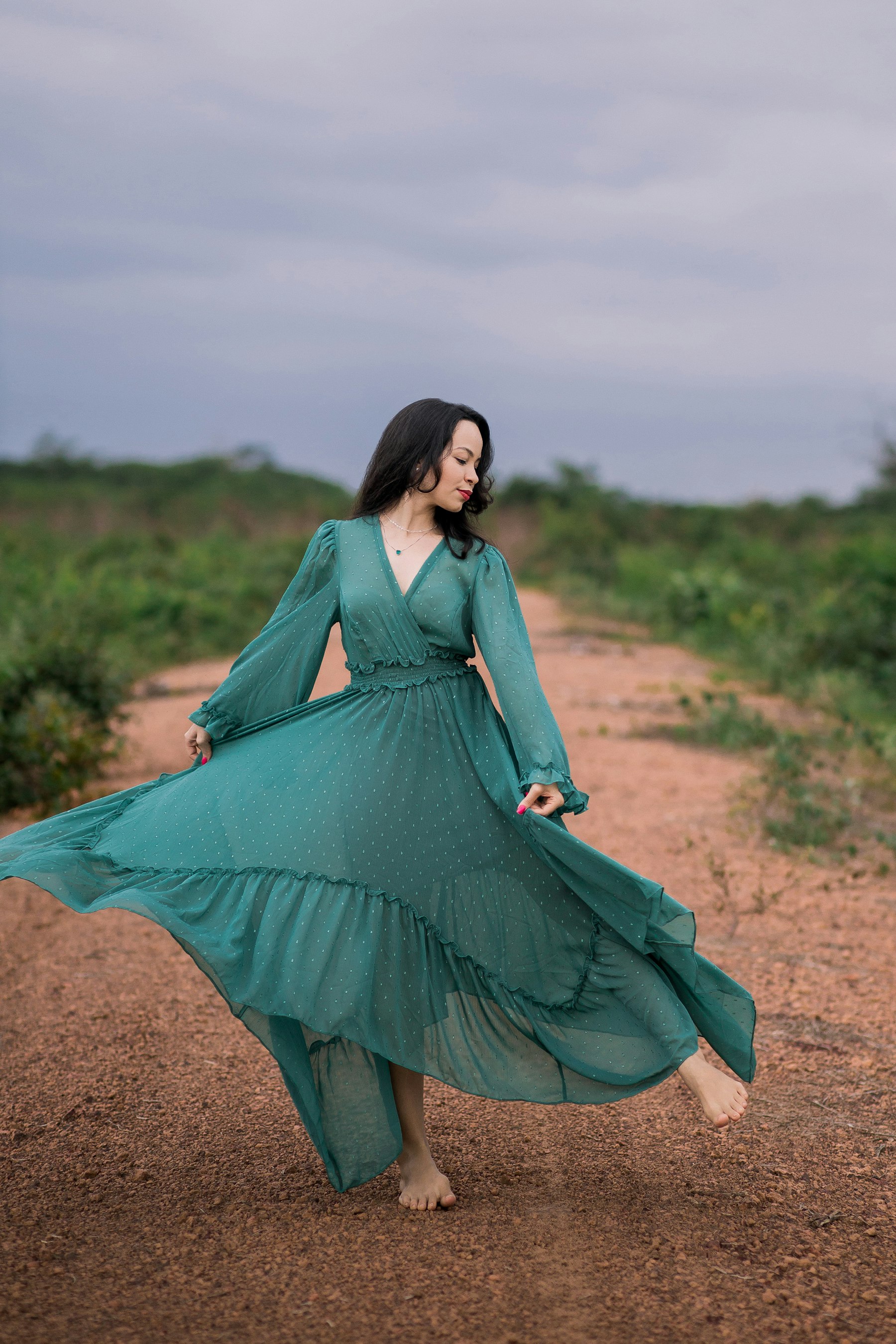 Model in a flowing emerald floor-length gown