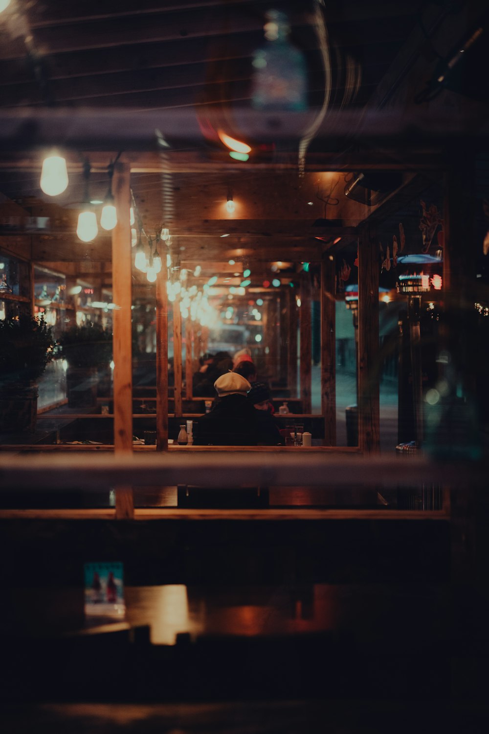 man in black jacket sitting on bench during night time