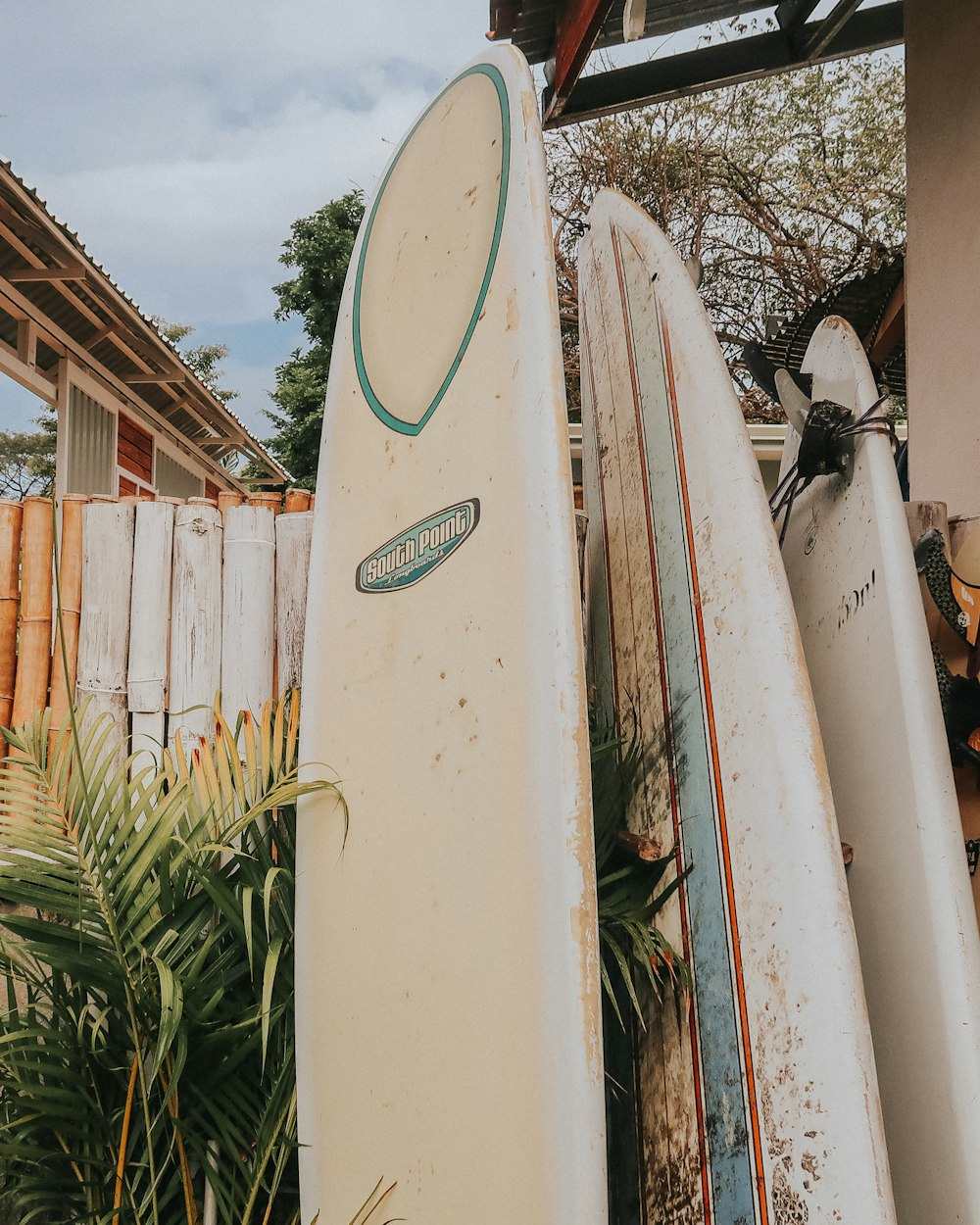 white surfboard on white wooden fence