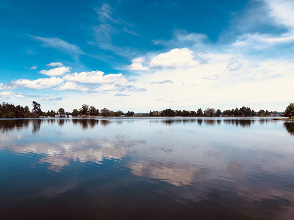 body of water under blue sky and white clouds during daytime