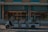 A small, open-sided electric vehicle is parked in front of a building with signs reading 'Parsian AliQapu Hotel' and 'Venice Italian Restaurant' in both English and Persian. The building features decorative turquoise and brickwork patterns.