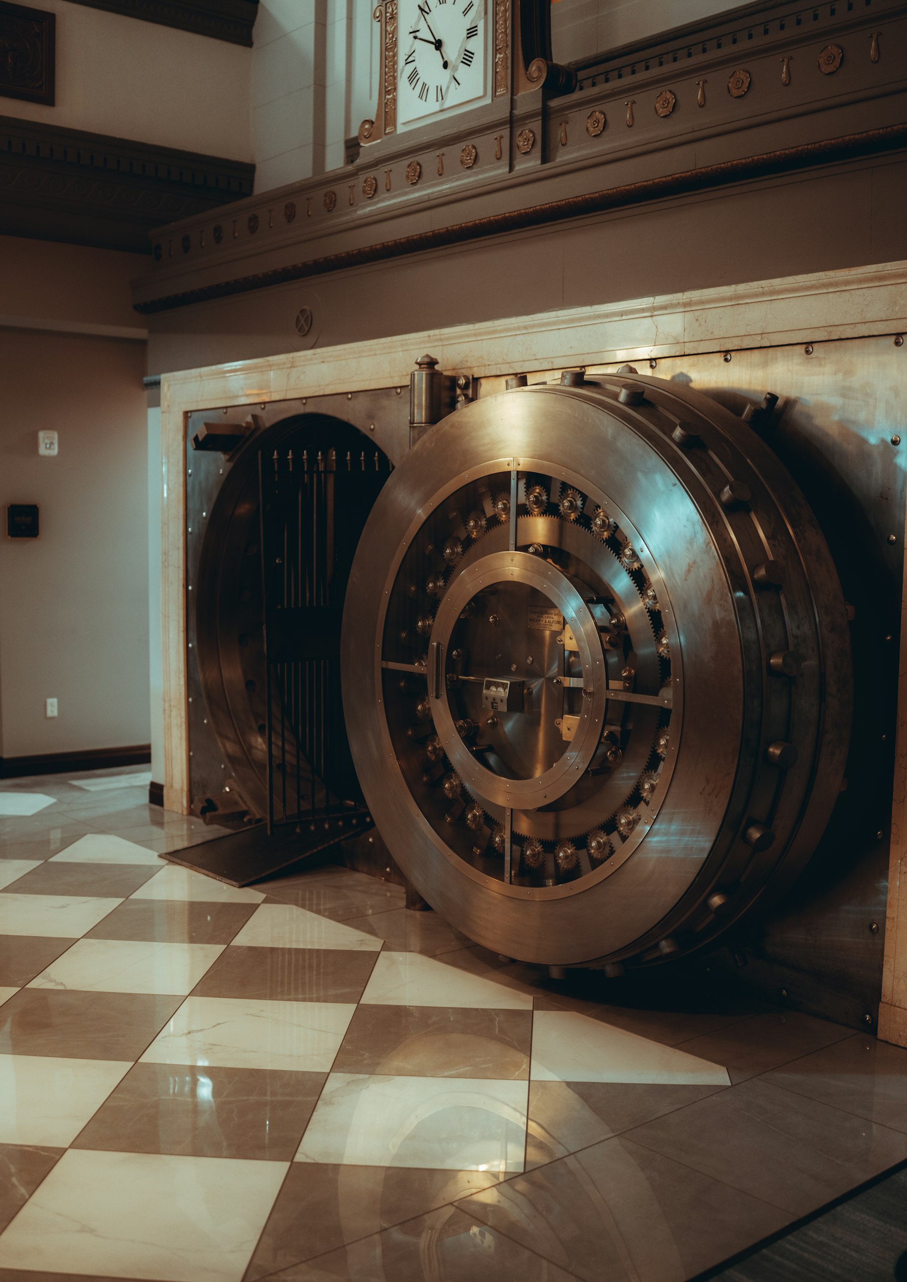 An open brass bank vault door with checkerboard floor — the Bank Heist room at Vault Escape Experiences, Portland