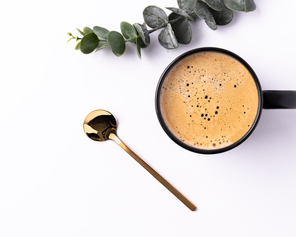 brown powder on white ceramic mug beside brown wooden spoon