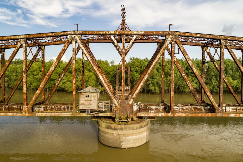 brown bridge over water under white clouds during daytime