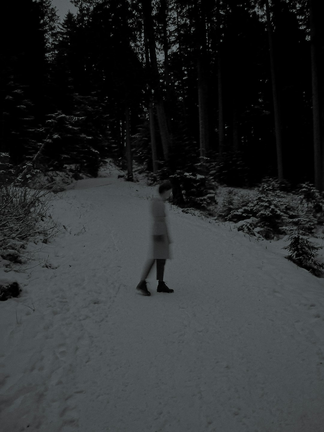 person in white jacket and black pants walking on snow covered ground during daytime