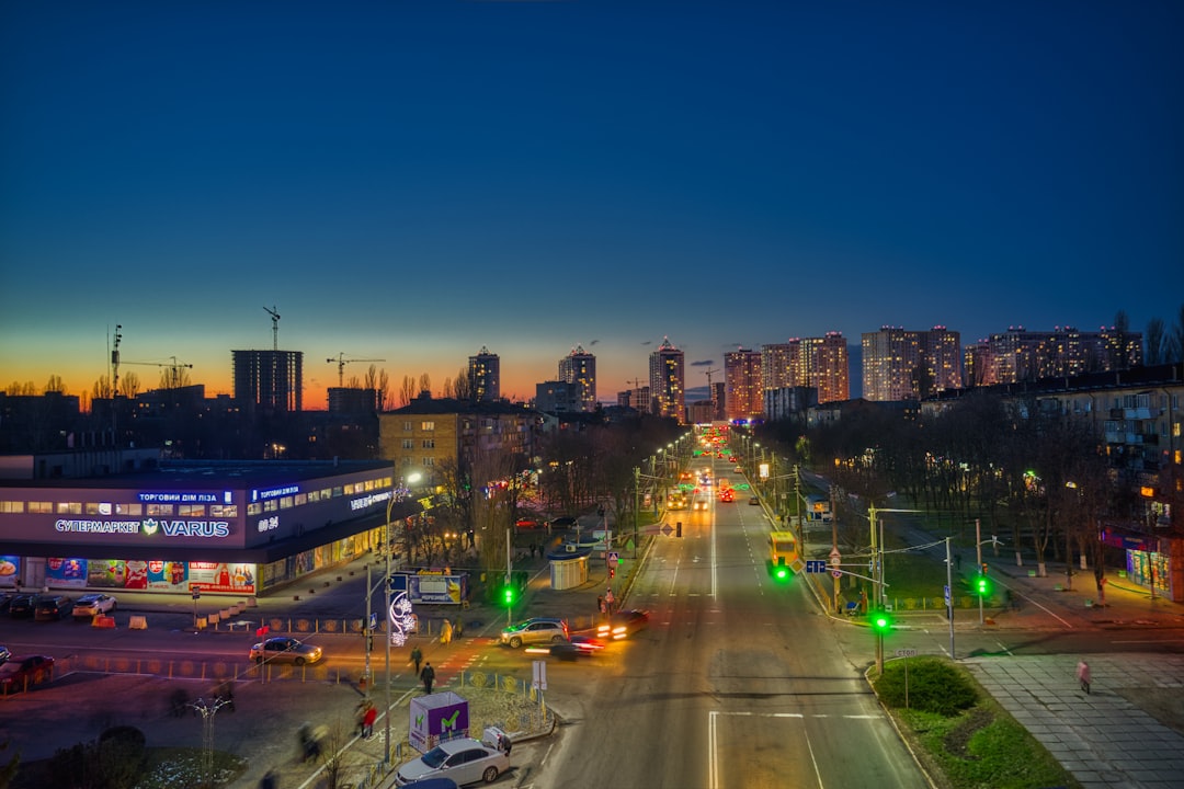 cars on road near high rise buildings during night time