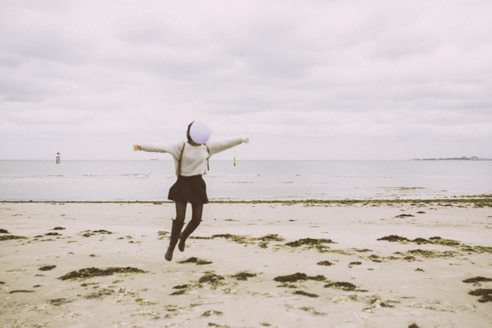 woman in black shorts holding white surfboard on beach during daytime