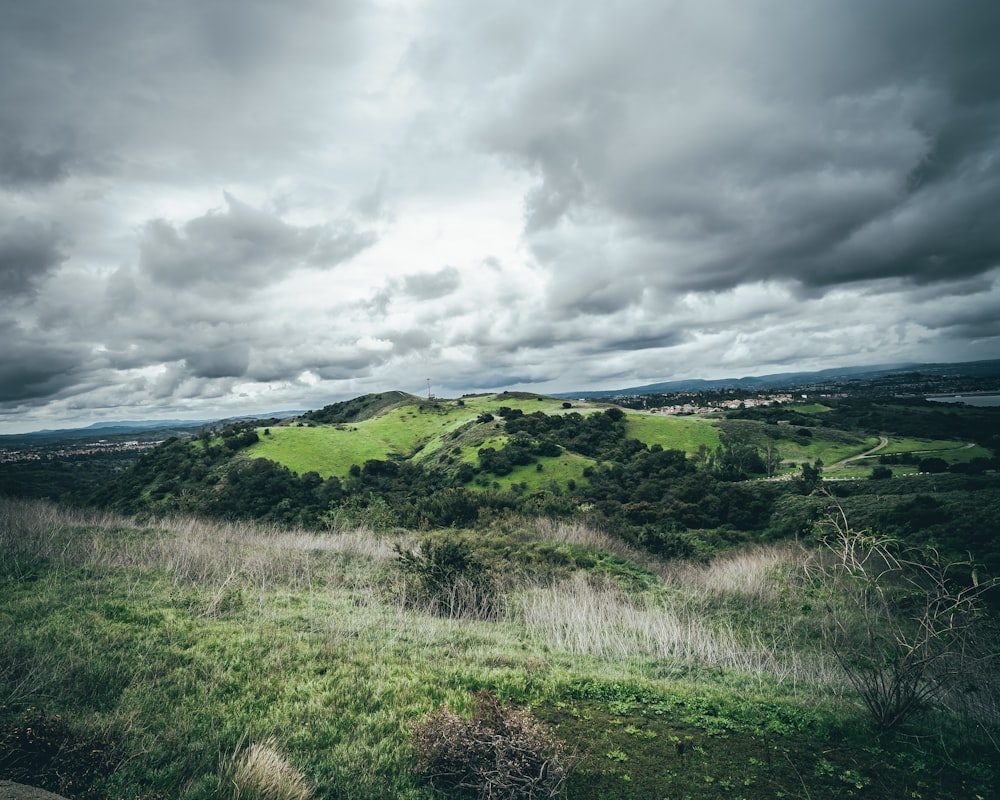 green grass field under cloudy sky during daytime