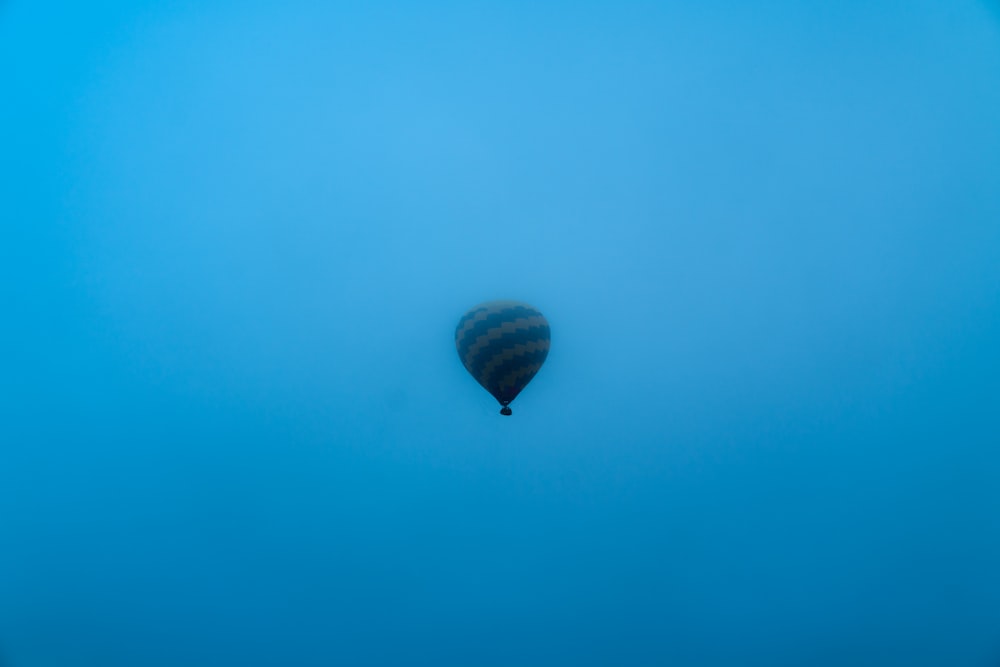 black hot air balloon in the sky