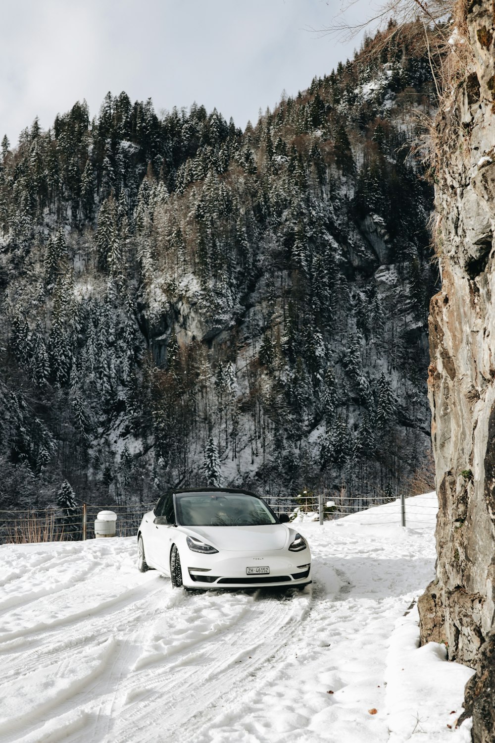 white car covered with snow near brown mountain during daytime