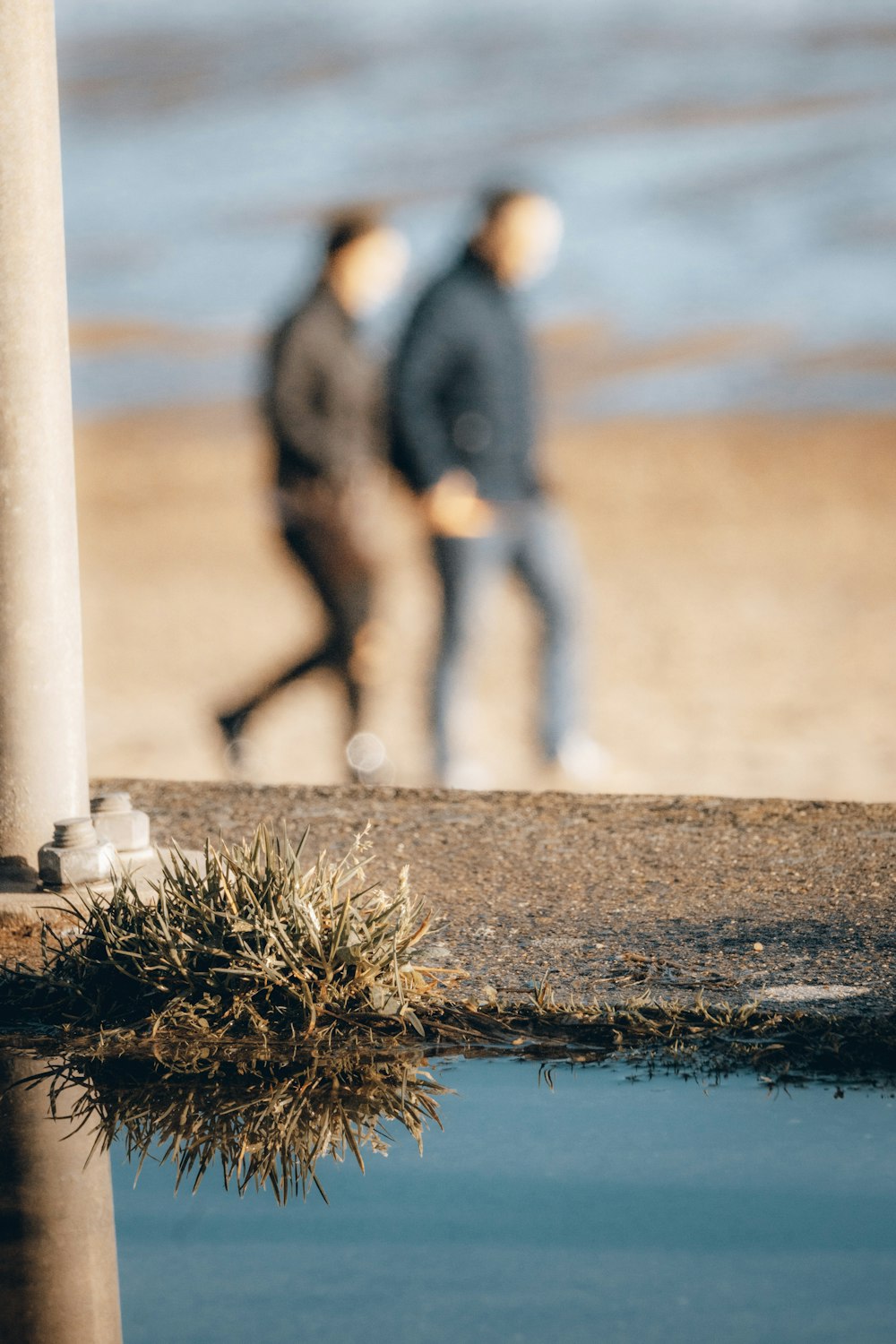 man in black jacket standing beside body of water during daytime