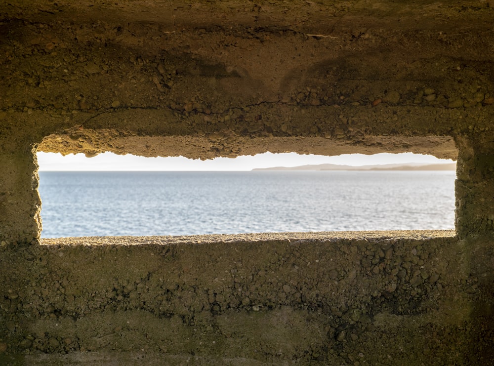 formação rochosa marrom perto do corpo de água durante o dia
