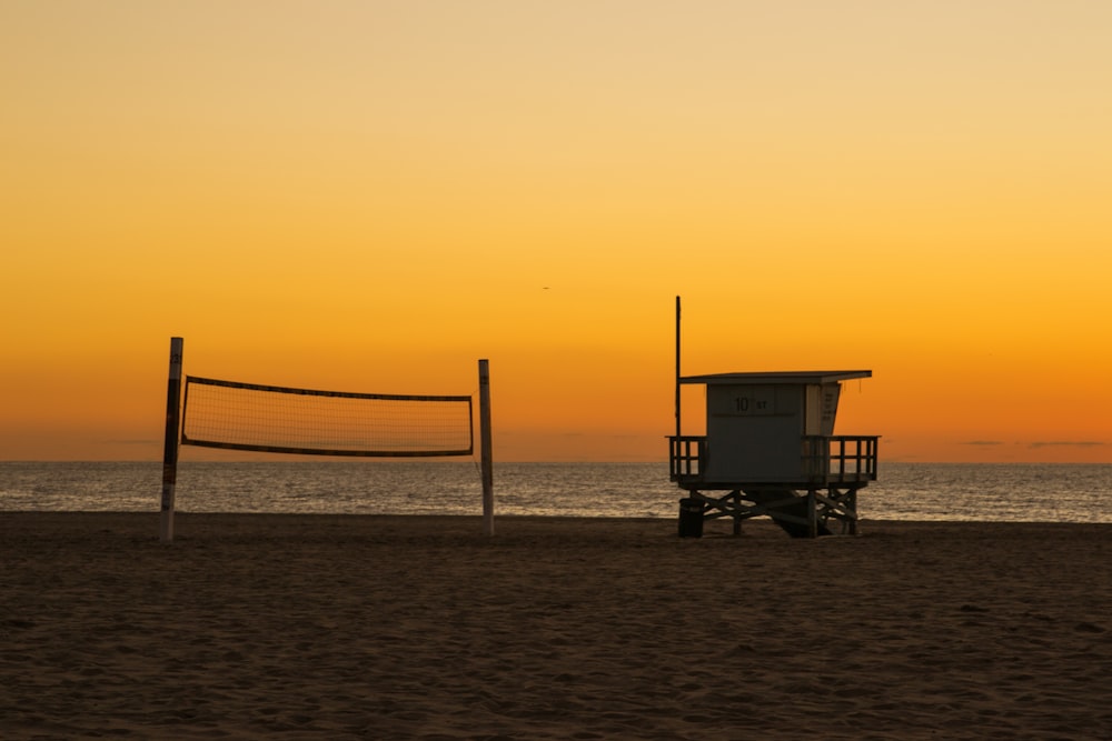 Silhouette des Rettungsschwimmerturms am Strand bei Sonnenuntergang