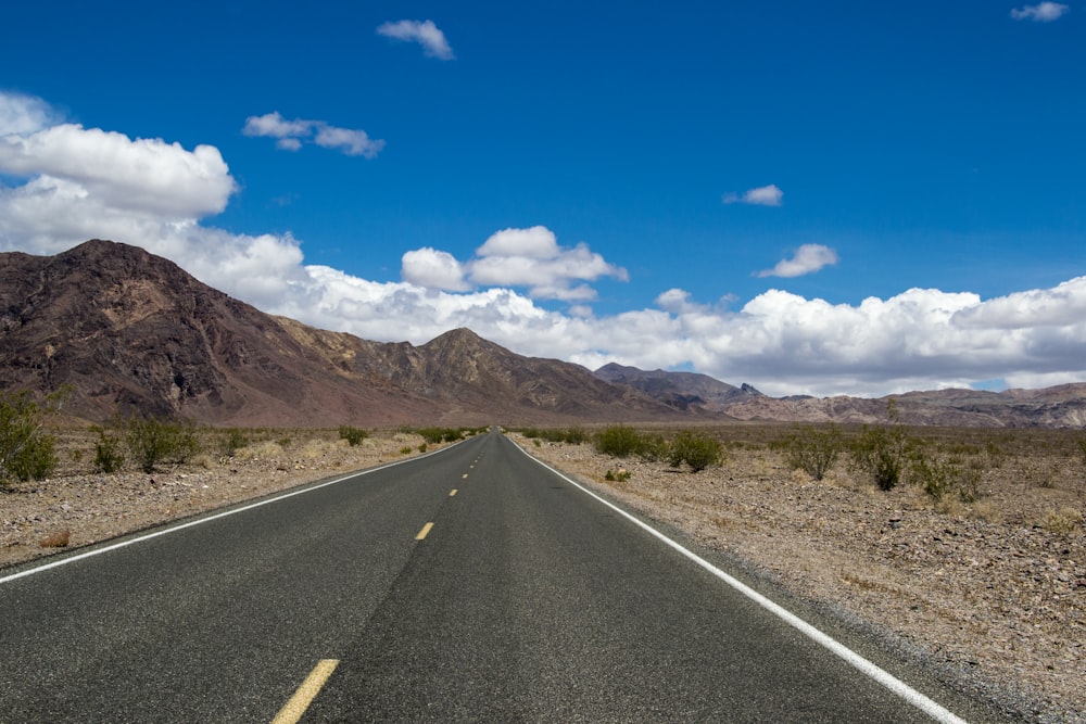 gray concrete road under blue sky during daytime