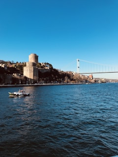 white boat on sea near bridge during daytime