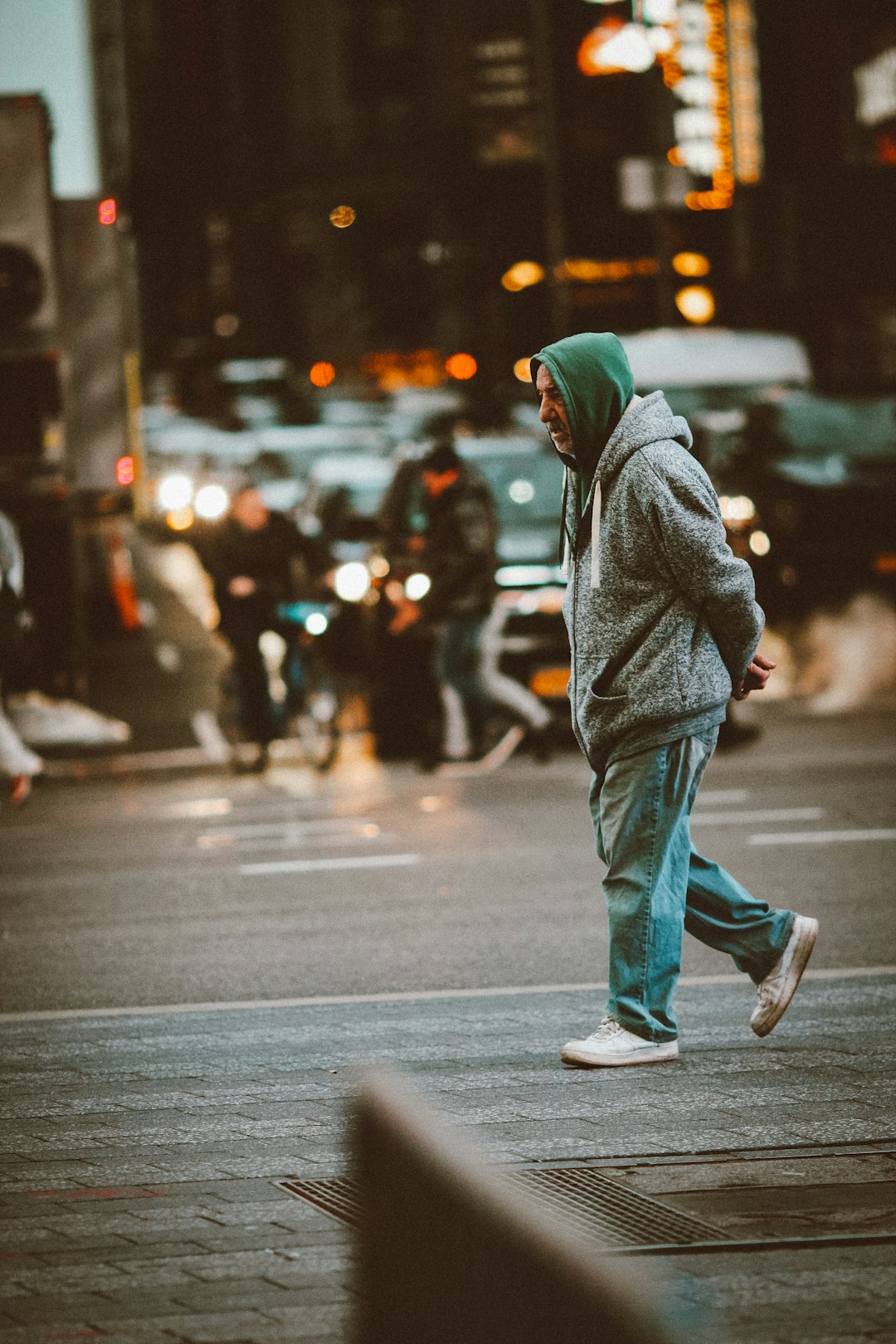 person in gray hoodie walking on street during daytime