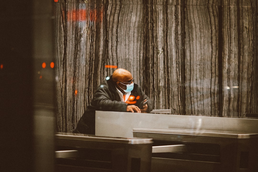 man in black jacket wearing orange goggles sitting on chair