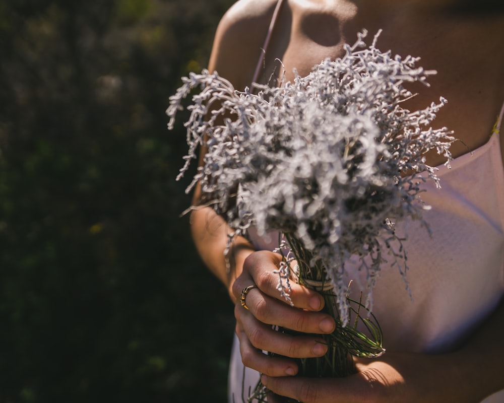 woman in white tank top holding white powder