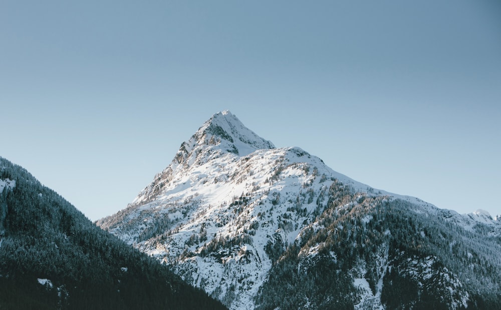 montagne enneigée sous ciel bleu pendant la journée